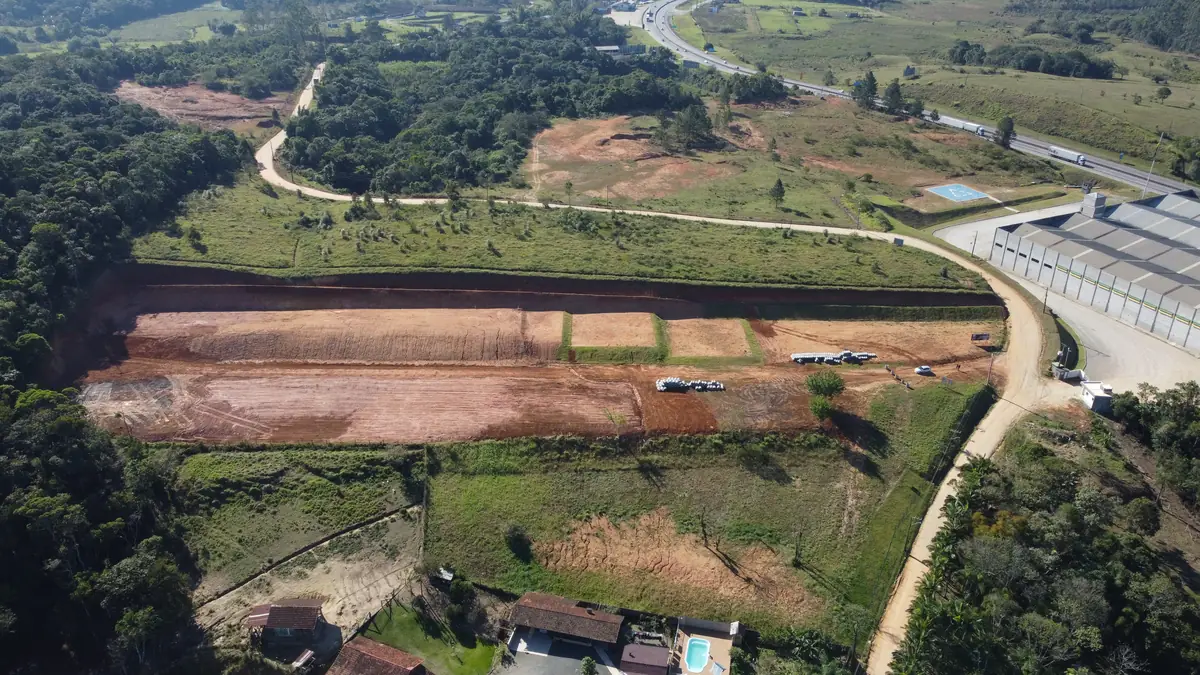 Vista aérea da gleba terraplanada, com o traçado das vias e a BR-101 ao fundo
